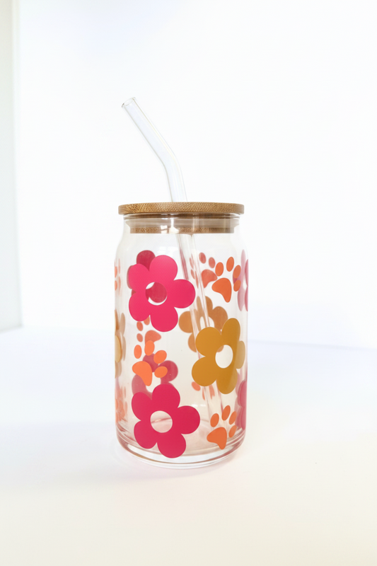 Glass tumbler with floral design and wooden lid on a white background